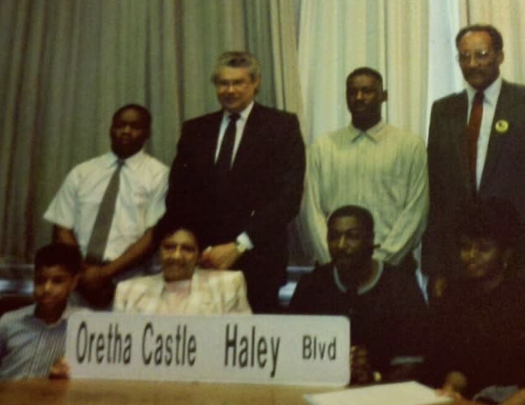 Historic photo from the Oretha Castle Haley Boulevard street naming ceremony, featuring community members and officials holding the new street sign